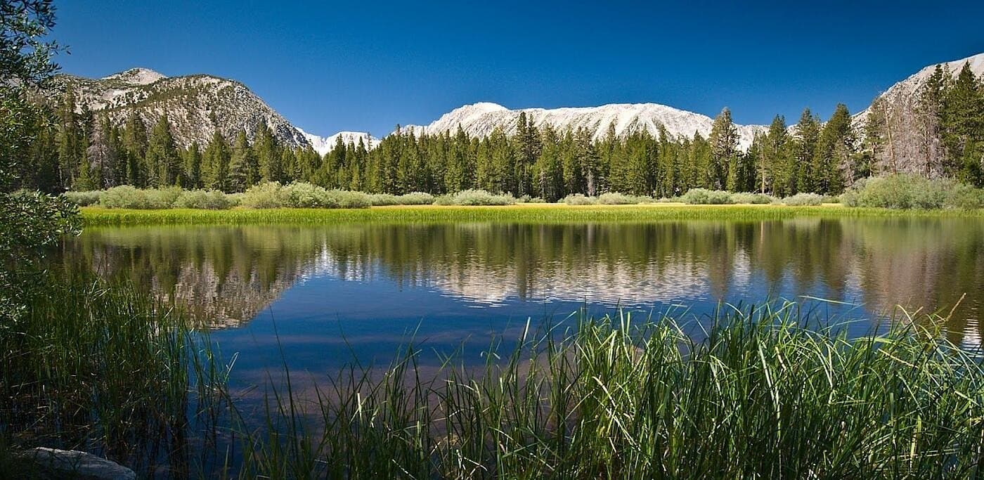 An alpine lake below snow-capped peaks in the Uinta Mountains